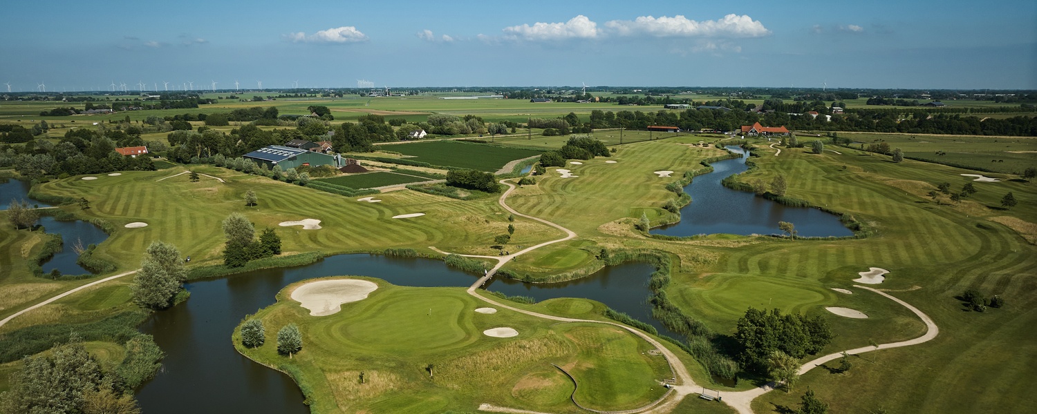 Golfball neben einem Loch auf einem grünen Golfplatz